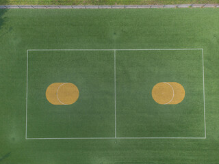 Korfball sports ground court seen from above. green field with yellow circles. Drone aerial top down shot
