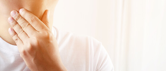 sore throat pain. Closeup of young man sick holding her inflamed throat using hands to touch the...