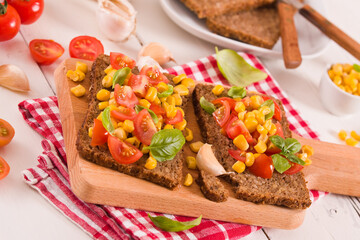 Rye bread withsweet corn, basil and tomato.