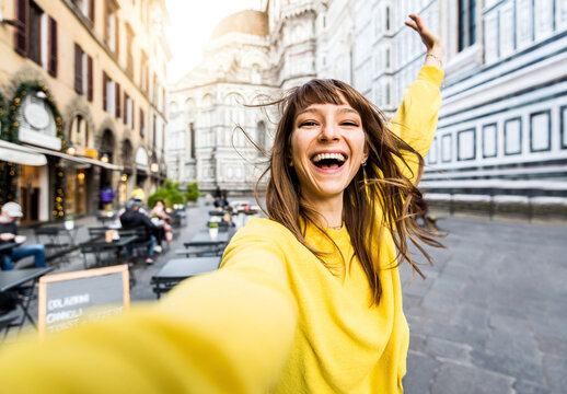 Tourist female visiting Florence cathedral, Italy - Traveller girl taking selfie portrait in front of Il Duomo di Firenze or Basilica di Santa Maria del Fiore - Italian touristic attraction concept