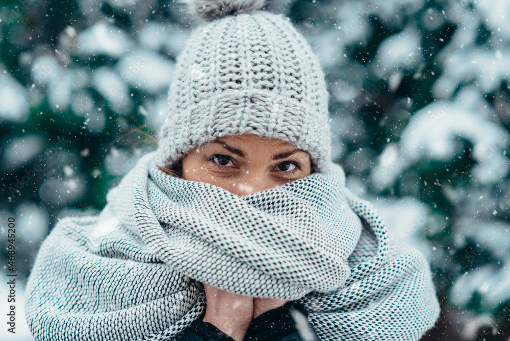 Wall mural beautiful young woman wearing scarf and a a hat on a cold winter day