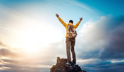 Man traveler on mountain summit enjoying nature view with hands raised over clouds - Sport, travel business and success, leadership and achievement concept