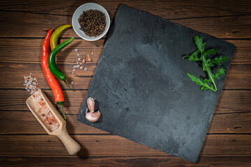 rustic cutting board with rosemary and spices , dark rustic wooden background, top view, place for...