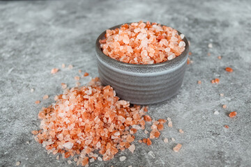 Pink himalayan rock coarse salt in a gray boel on gray background