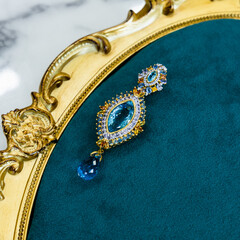 The brooch is made of gold and gemstones with the elaboration of artisans.