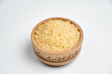 white rice grains in a wooden bowl