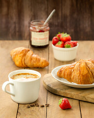 croissants and coffee for breakfast on wooden table