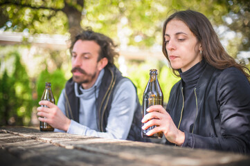 Couple in quarrel, boyfriend and girlfriend drinks beer from bottle