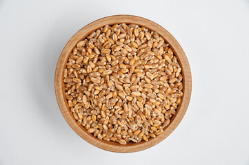 spelled grain in a wooden bowl on a white background