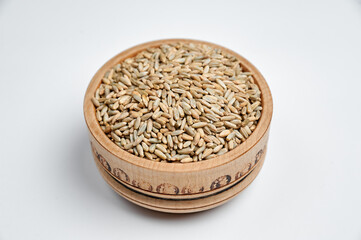 sunflower seeds in a wooden bowl on a white background