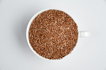 flax grain in a white cup on a white background