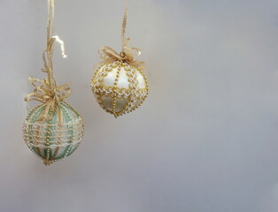 Two Metallic Gold Aqua White Beaded Ornaments with Gold Ribbons on Right Upper Corner of White Background with Room for Text