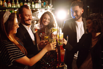 Cheering and drinking cocktails. Group of people partying in a nightclub and toasting drinks with cocktails. Party, celebration, drink, birthday concept.