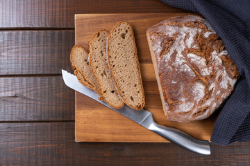 Freshly baked rye bread sliced in the traditional way. Single object on a wooden background. Top view, copy space.