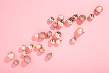 Beautiful shiny pink decorative balls on a pink background. Top view, flat lay.