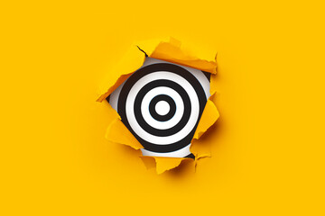 Bright yellow torn paper cardboard inside in a hole target black and white.