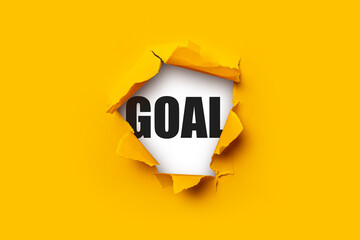 Bright yellow torn paper inside in a hole the inscription Goal on a white background.