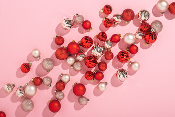 Pink and red decorative balls on a pink background. Top view, flat lay.
