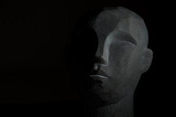 portret kamiennej głowy na czarnym tle