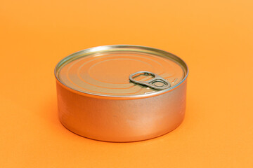 Unopened Tin Can with Blank Edge on Orange Background. Canned Food. Aluminum Can for Safe and Long Term Storage of Food. Steel Sealed Food Storage Container