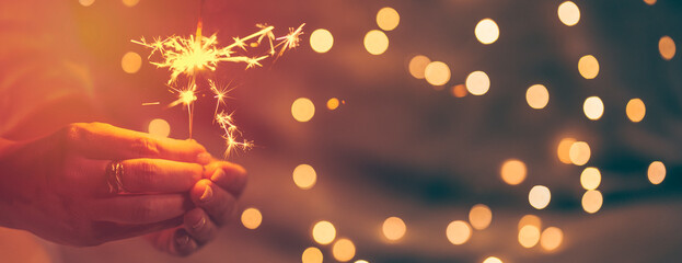 sparkler in the hands of a woman, christmas background, vintage colors