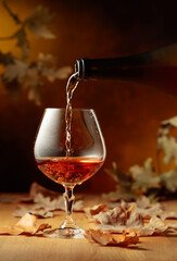 Cognac is poured into a glass from a bottle.