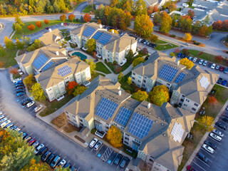aerial view of apartment buildings with solar panel installed on roof in autumn