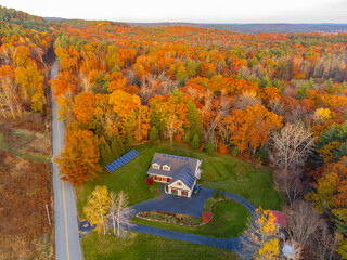 aerial view of country road and house in the autumn forest