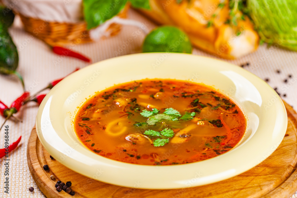 Wall mural Vegetable soup with herbs and spices in white plate