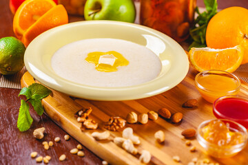 Semolina porridge with nuts, jam and fruits on wooden board
