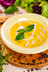 Cheese cream soup with chicken on wooden board