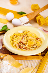 Spaghetti carbonara with bacon and parmesan cheese in beige plate