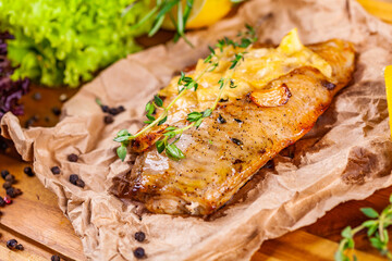 Baked seabass fillet with herbs and spices on wooden board