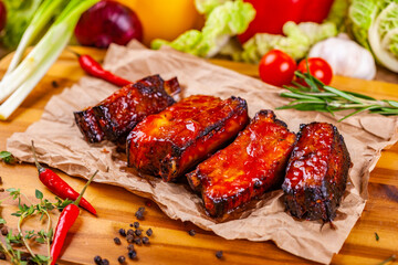 Grilled barbecue pork ribs with spices and herbs on wooden board
