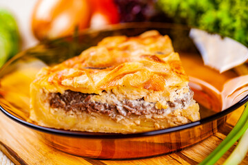 Meat pie with potato and onion in glass bowl