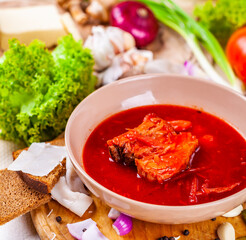 Borscht with vegetables and meat in pink plate. Ukrainian cuisine