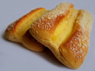 two butter buns with pudding on a gray  background. side view .sweet pastries