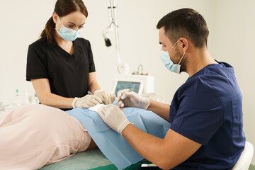 Doctor and nurse during dermatological surgery