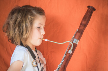 jeune fille en train de jouer du basson - obrazy, fototapety, plakaty