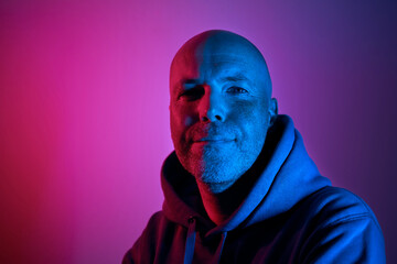 Portrait illuminated of neon lighting. Successful and determined middle aged man. .