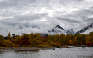 Fall colors and low stormy clouds along the Wenatchee River in Washington State.