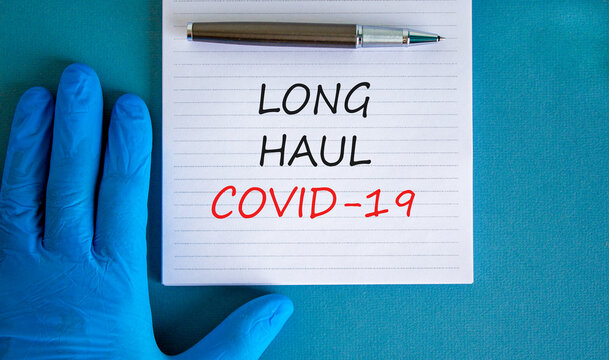 COVID-19 Long-haul Covid Symptoms Symbol. White Card With Words Long Haul Covid-19. Doctor Hand, Pen, Beautiful Blue Background Copy Space. Medical, COVID-19 Long-haul Covid Symptoms Concept.