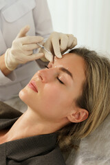 Woman during facial filler injections in aesthetic medical clinic - obrazy, fototapety, plakaty