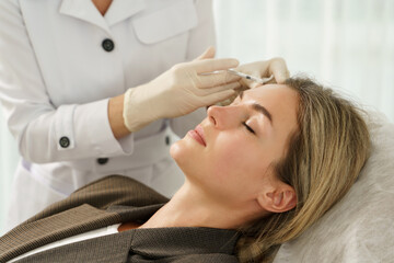 Fototapeta na wymiar Woman during facial filler injections in aesthetic medical clinic
