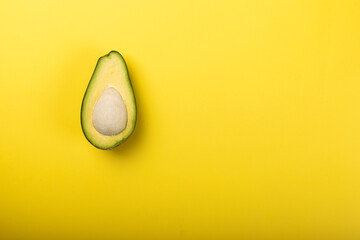 avocado on a yellow background with place for text. creative food concept.