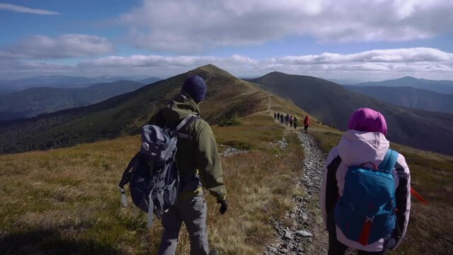 happy group of people hiking mountains together in nice weather 