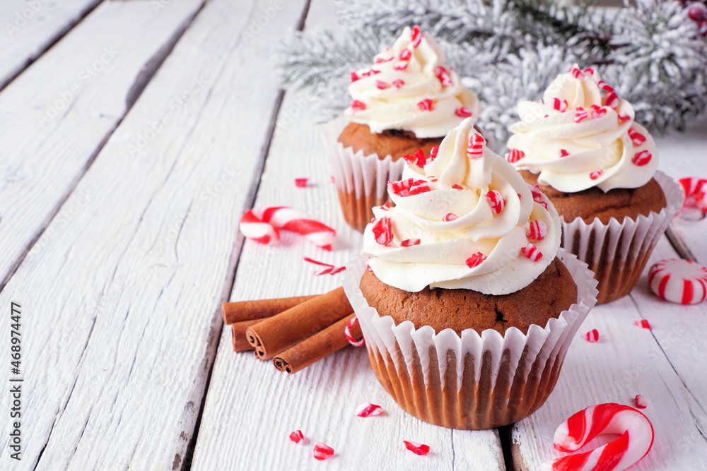 Poster christmas candy cane cupcakes with creamy frosting. close up on a rustic white wood table background