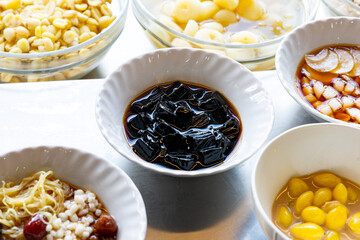 Syrup in a small white cup of grass jelly