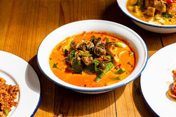 River snail red curry in red curry coconut milk soup in bowl. Thai Food