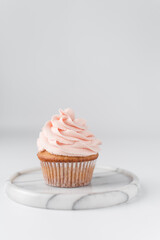 Vanilla cupcake with pink frosting, plain cupcake with pastel pink buttercream